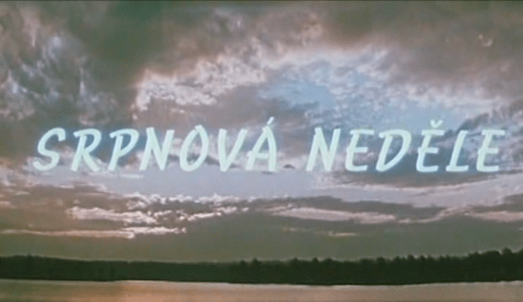 Title card for Srpnová neděle (August Sunday) depicting a pink sunset over a large pond