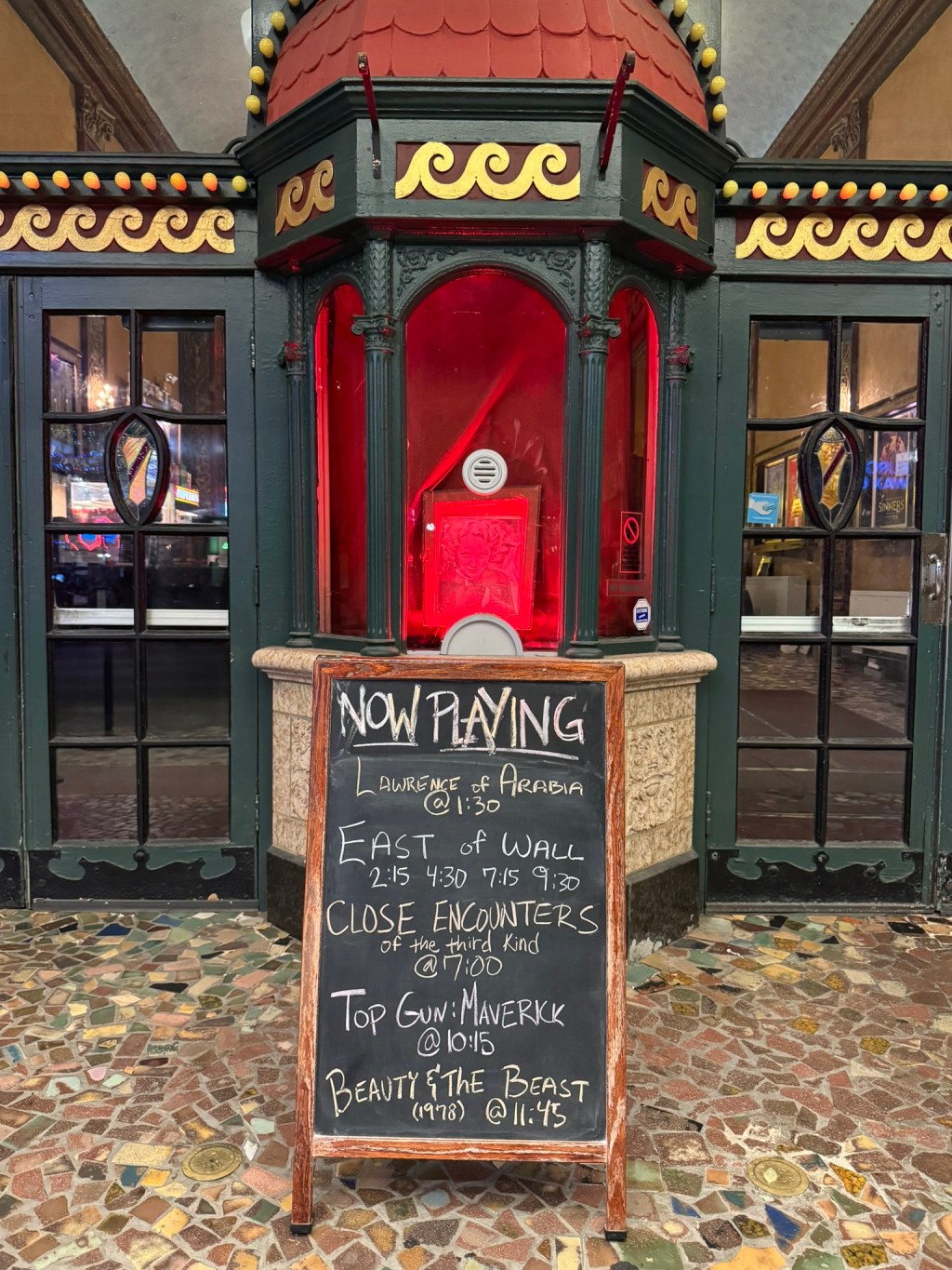Chalkboard sign in front of the Music Box Theatre in Chicago. It has the movies screening that day, and at the bottom is Beauty and the Beast.